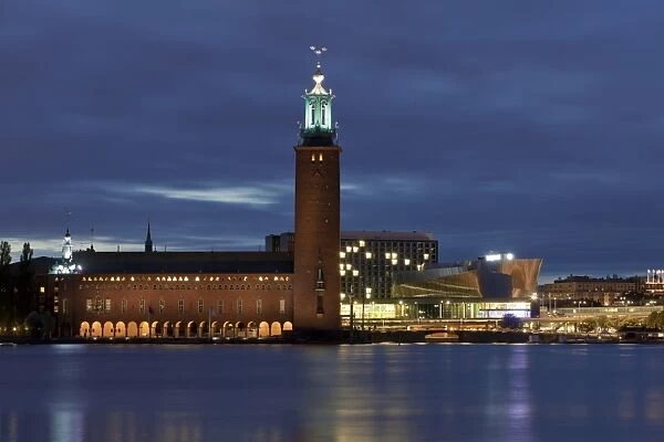 View of waterfront with city hall illuminated at night, Stockholm City Hall, Kungsholmen Island, Riddarfjarden