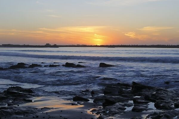 View of waves and rocks on beach at sunset, Lamberts Bay, Western Cape, South Africa, October