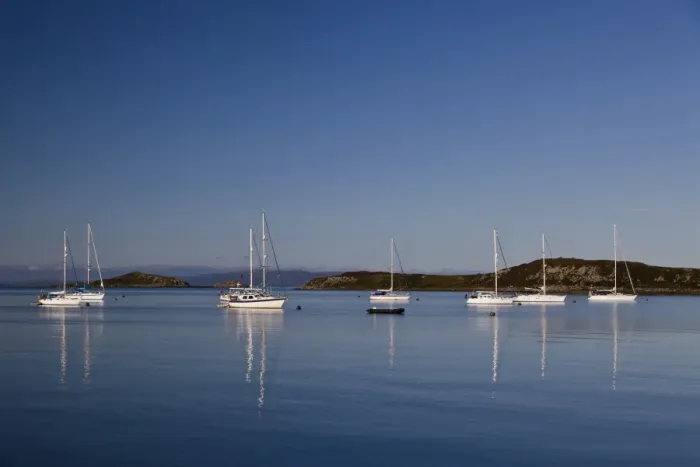 Framed Print : View of yachts moored in bay, with Small Isles in background, Craighouse Bay, Isle of Jura, Inner Hebrides, Scotland