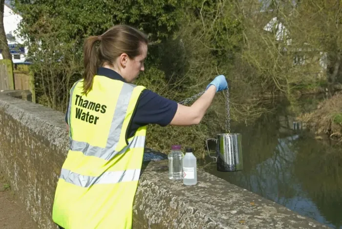 Framed Print : Water quality scientist from Thames Water, taking samples to be tested for traces of metaldehyde, carbetamide and propyzamide, River Cherwell, Cropredy Bridge, Oxfordshire, England, march