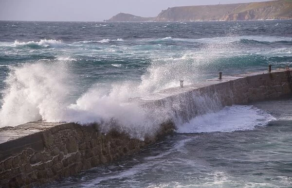 Waves breaking over harbour wall, looking towards Cape Cornwall, Sennen Cove, Sennen, Cornwall, England, May