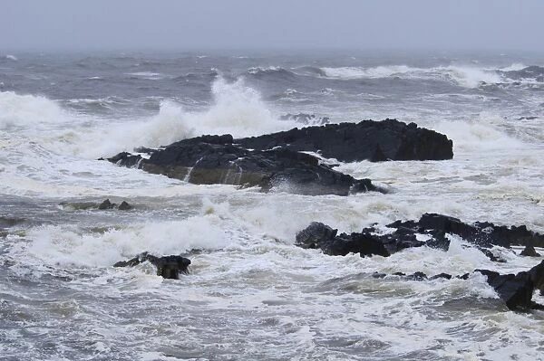 Waves crashing against rocks in stormy weather on east coast, Macduff, Aberdeenshire, Scotland, August