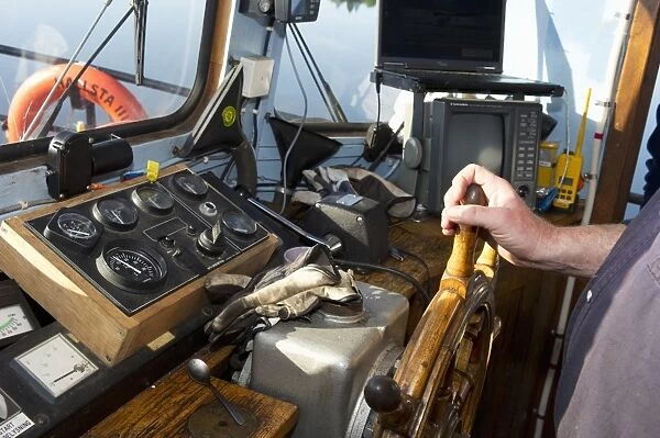 Wheel and controls in control cabin on boat, near Hargshamn, Baltic Sea, Uppsala County, Sweden, june