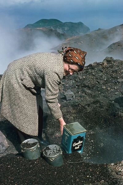 Woman baking bread in heat of lava flow, Eldfell Volcano, Heimaey, Westmann Isles, Iceland, june 1976