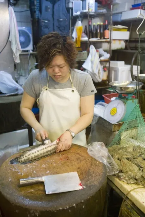 Framed Print : Woman preparing fish beside frogs in net at fish market, Kowloon, Hong Kong, China Framed Print : Woman preparing fish beside frogs in net at fish market, Kowloon, Hong Kong, China