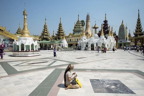 Woman sitting with prayer beads at Buddhist temple, Shwedagon Pagoda, Yangon, Myanmar, March