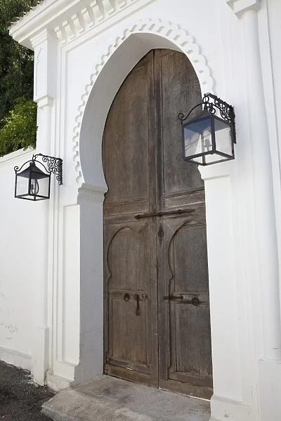 Wooden door and lanterns in street of coastal city, Tangier, Morocco, april