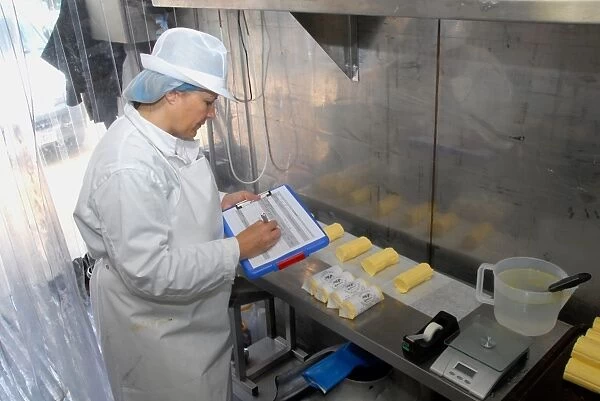 Worker recording batch of organically made butter from unpasteurized milk, on organic dairy farm, Hook and Son