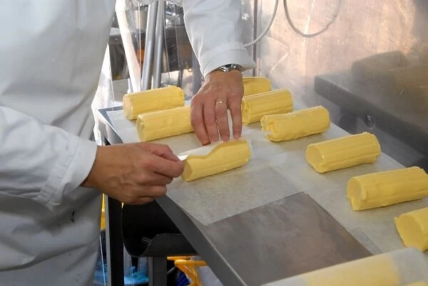 Worker wrapping up organically made butter from unpasteurized milk, on organic dairy farm, Hook and Son, Longleys Farm