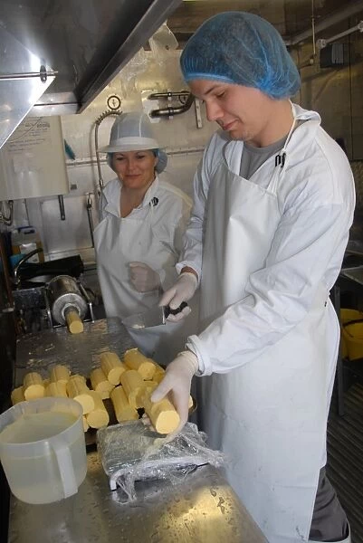 Workers weighing out butter patts, making organically made butter from unpasteurized milk, on organic dairy farm