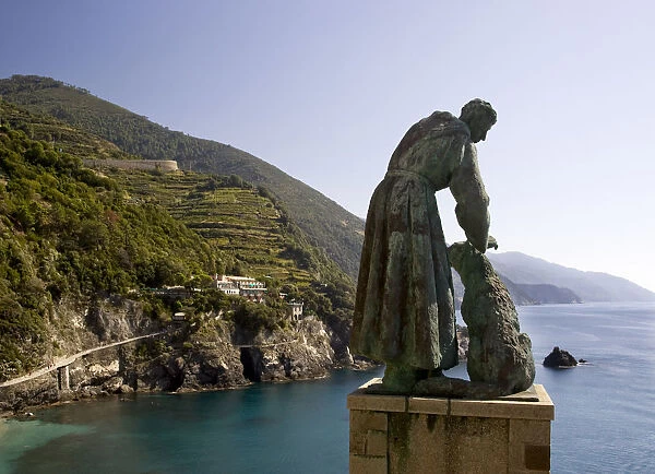Europe, Italy, Cinque Terre, Monterosso. A statue of St. Francis of Assisi petting a dog