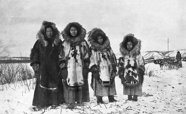 ALASKA: ESKIMO WOMEN. A group of four Eskimo women standing outside, dressed in