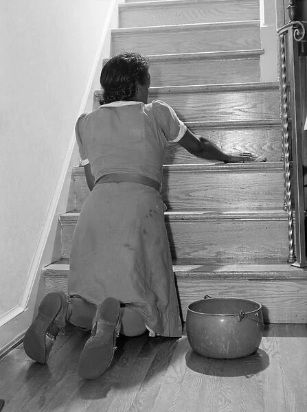 MAID CLEANING, 1941. An African American maid cleaning a staircase in Washington, D