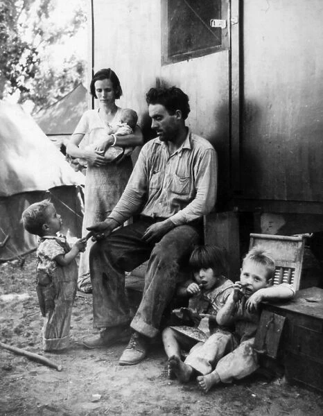 MIGRANT CAMP, 1935. An ex-tenant farmer from Texas with his family in a camp for
