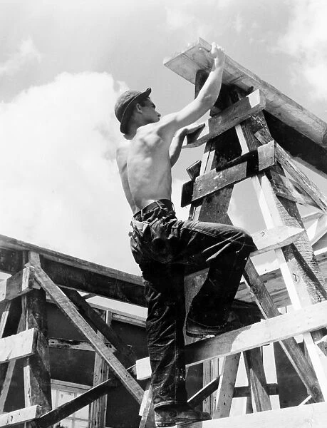 NEW DEAL: C. C. C. 1940. Worker for the Civilian Conservation Corps climbing up