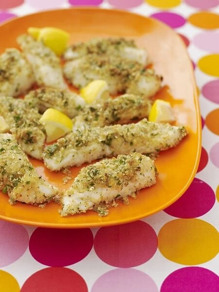 Baked cod coated with crumbs of parmesan, served with lemon slices on a plate