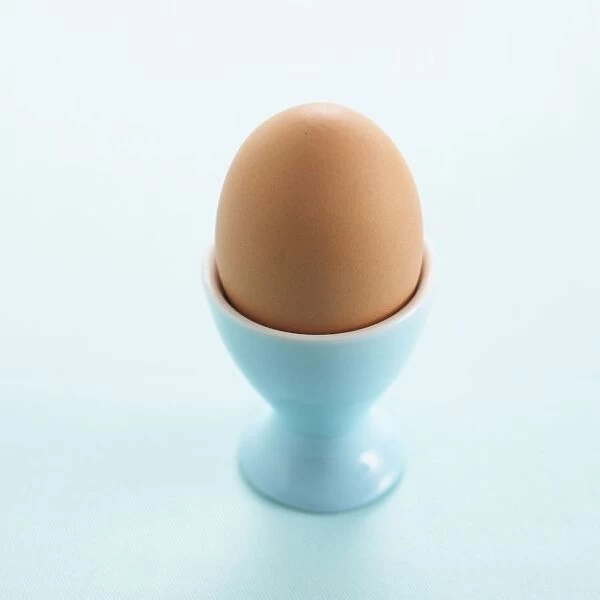 Whole boiled egg in blue egg cup