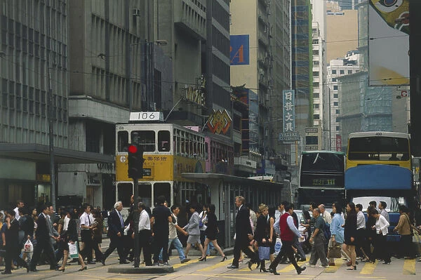 China, Hong Kong Island, pedestrians crossing a road during rush hour