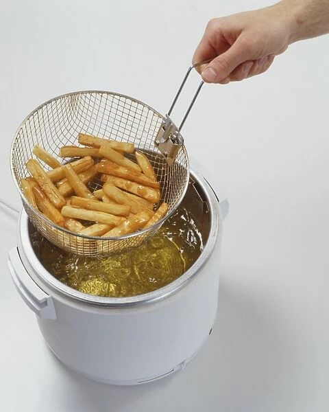 Chips in Deep Fat Fryer Metal Basket Lifted out of Oil