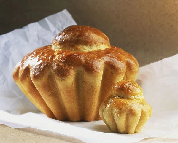 Close-up of an individual brioche and the larger brioche a tete