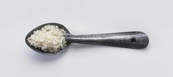 Coarse rock salt on metal spoon