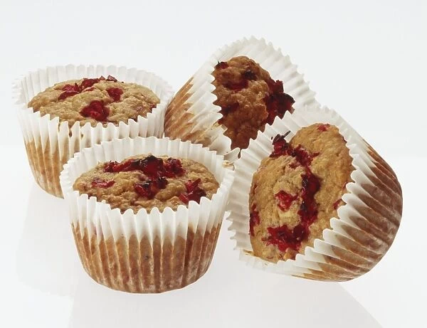 Four cranberry muffins in paper cases