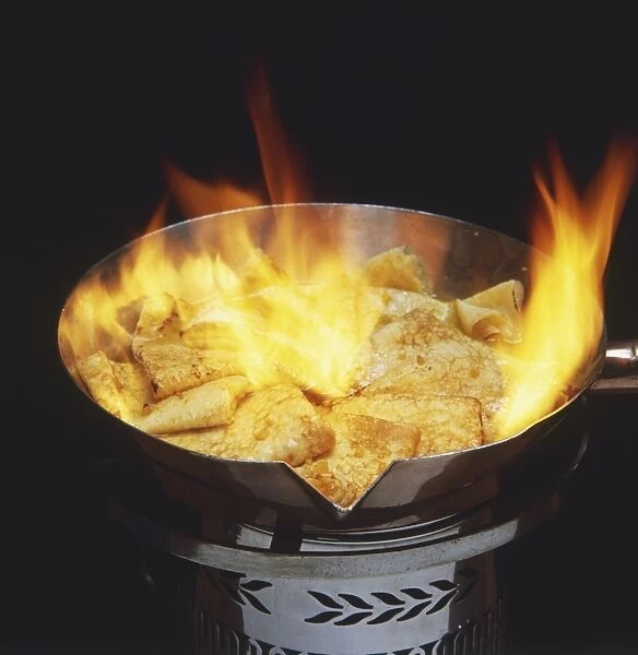 Crepes being flambed in a pan