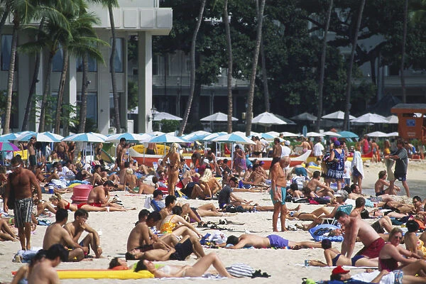 The crowded golden sand of Waikiki Beach, Hawai is most popular visitor destination
