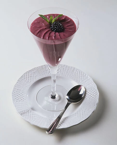 A dessert glass containing a blackberry dessert