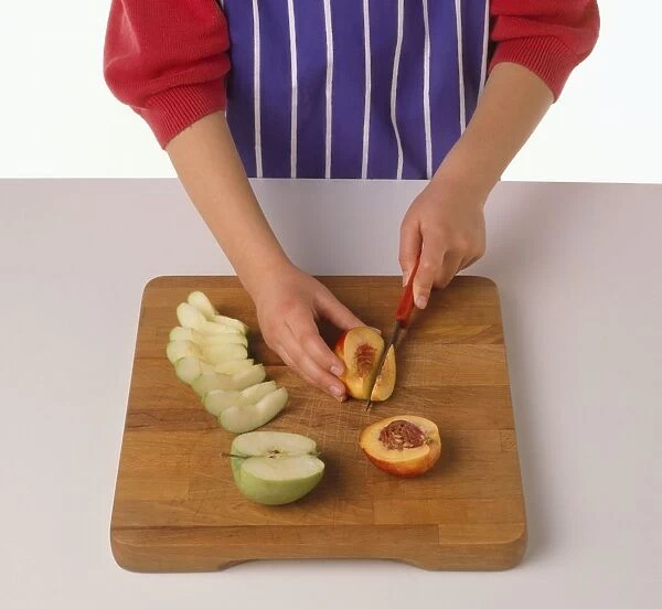 Girl slicing peach on chopping board, apple slices nearby, close-up