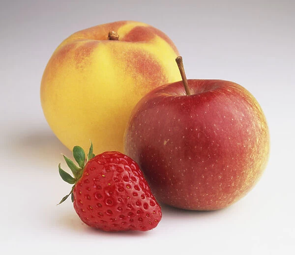 A peach, and apple and a strawberry, close up