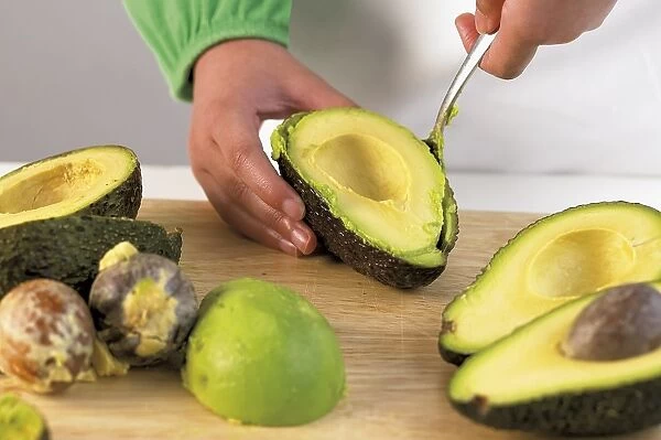 Person scooping avocado flesh