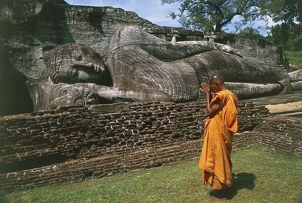 Sri Lanka, Ancient City of Polonnaruwa, Reclining Buddha statue and praying monk