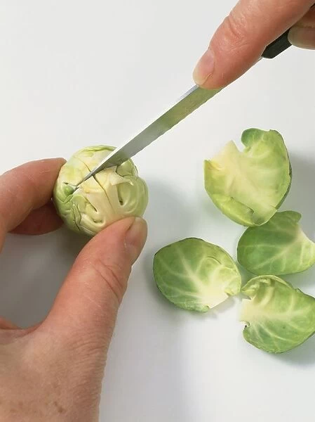 Using kitchen knife to slice Brussels sprout