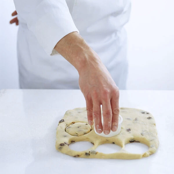 Using a round cutter to stamp out circles of dough