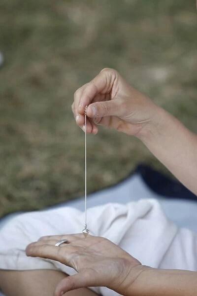 Woman using a pendulum at a Kundalini Yoga festival