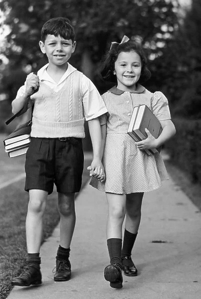 Young girl & boy walking to school w  /  books