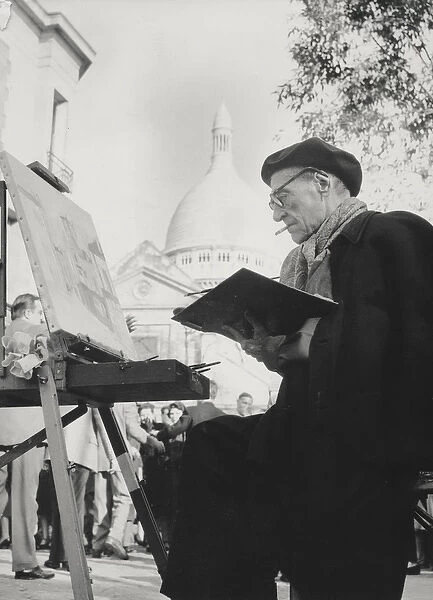The artist Maurice Utrillo painting at his easel in Montmartre, Paris, 1950s (photo)