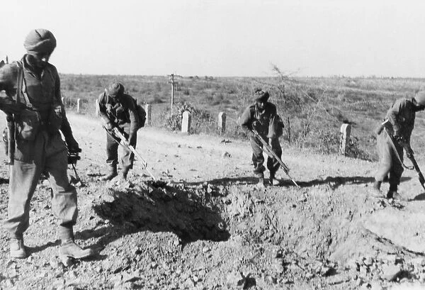 Indian soliders searching for mines along a dirt road, 1941 (b  /  w photo)