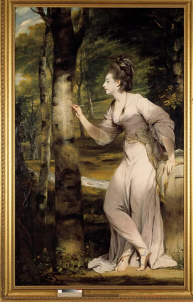A woman of great elegance gives a name on a tree trunk in a romantic atmosphere