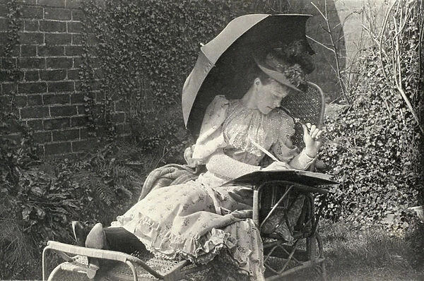 A woman writing on a sun lounger (b  /  w photo)