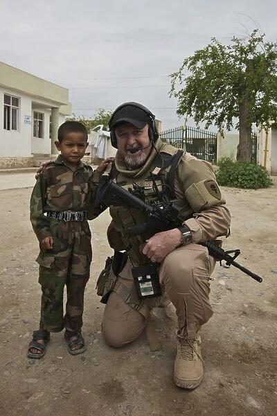 U. S. Contractor poses for a picture with an Afghan child