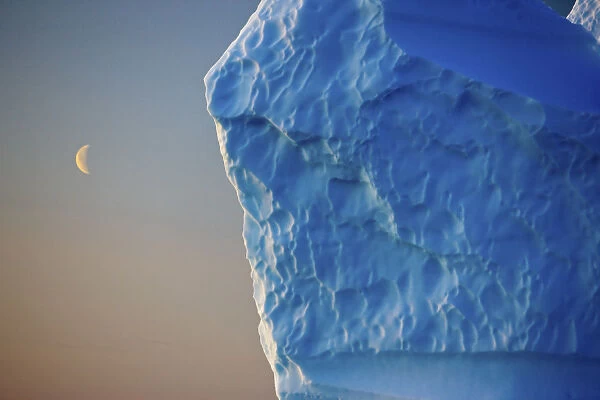 Edge of iceberg with the moon in the sky, Greenland, August 2009