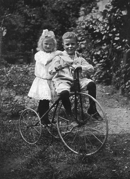 Two children on a tricycle, 1911-1912. Artist: CW Perry