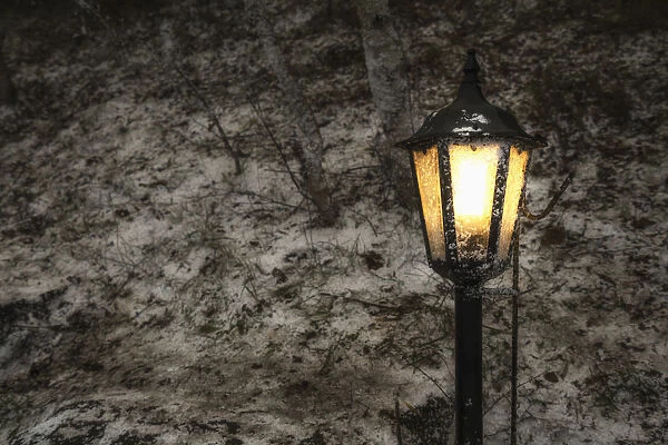 Illuminated Lamp Post Against A Stone Wall; Beamish, England