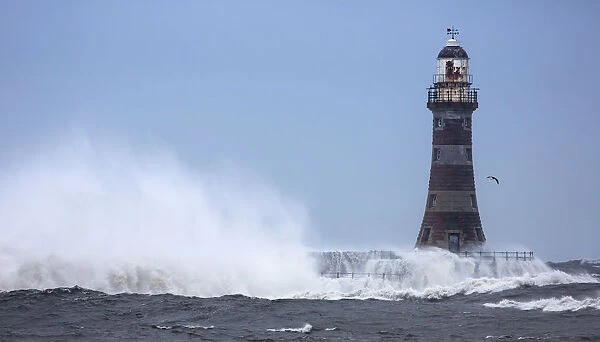 Splashing water from a crashing wave against a lighthouse; Sunderland Tyne and Wear England