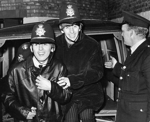 The Beatles members George Harrison and Ringo Starr clown around dressed in policemen
