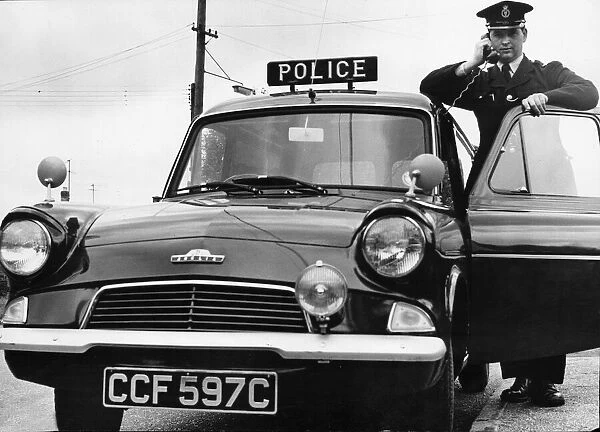 A Cambridgeshire police officer driving a Ford Anglia police car at Mildenhall