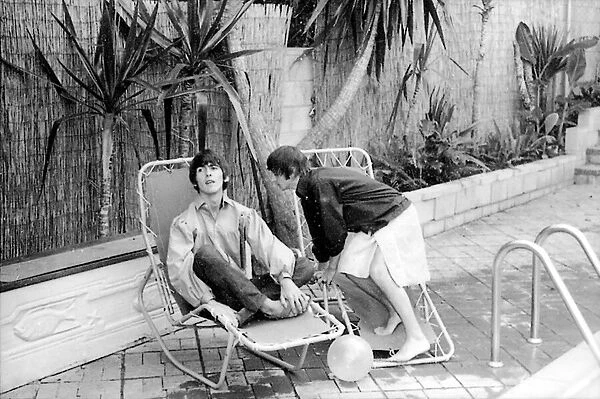 George Harrison and Ringo Starr relax by their swimming pool in Bel Air California
