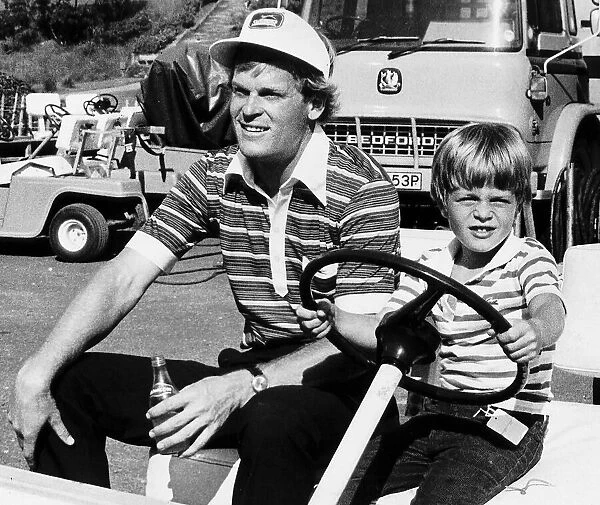 Golfer Johnny Miller holding a bottle of water sitting in electric golf buggy with his